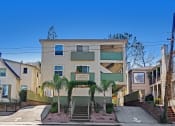 Thumbnail 2 of 36 - an apartment building with palm trees in front of it