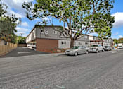 Thumbnail 3 of 38 - A street view with cars parked on the side of the road and a building in the background.