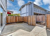 Thumbnail 45 of 53 - the back yard of a unit with a wooden fence and a gate