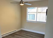 Thumbnail 19 of 43 - A room with a ceiling fan and a window with blinds.