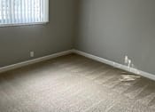Thumbnail 21 of 33 - A room with a carpeted floor and a window with blinds.