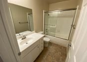 Thumbnail 16 of 23 - A bathroom with a sink, toilet, and shower.