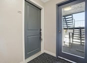 Thumbnail 72 of 92 - A blue door with a black handle is in a white hallway.