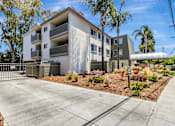 Thumbnail 26 of 43 - A modern apartment building with a driveway in front.