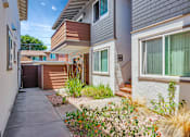 Thumbnail 13 of 25 - A house with a brown and white exterior and a small garden in front.
