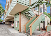Thumbnail 7 of 14 - A green building with a staircase leading to the second floor.