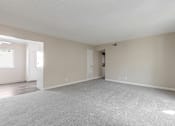 Thumbnail 38 of 51 - A large, empty room with a carpeted floor and white walls.
