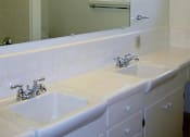 Thumbnail 18 of 38 - A white bathroom with a sink and mirror.