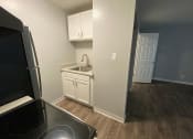 Thumbnail 34 of 51 - a kitchen with white cabinets and a black stove and refrigerator