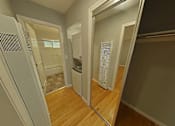 Thumbnail 18 of 47 - A hallway with a mirror on the wall and a washing machine in the background.