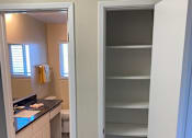 Thumbnail 29 of 43 - A white door is open to a room with a kitchen counter and cabinets.