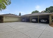 Thumbnail 12 of 47 - A house with a garage that has two cars parked in it.