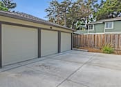 Thumbnail 24 of 27 - A garage with a brown roof and three white doors is shown.