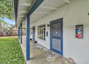 Thumbnail 7 of 21 - A white house with a blue door and a fire extinguisher on the wall.