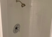 Thumbnail 27 of 31 - a small white shower with a silver shower head