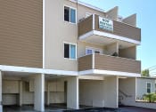 Thumbnail 29 of 31 - a apartment building with cars parked in front of it