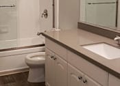 Thumbnail 20 of 30 - A white bathroom with a toilet, sink, and mirror.