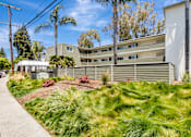 Thumbnail 31 of 43 - A modern building with a green lawn in front.