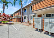Thumbnail 1 of 25 - A sunny day at a residential complex with a parking lot in the foreground.