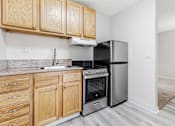 Thumbnail 24 of 29 - A kitchen with wooden cabinets and stainless steel appliances.