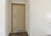Thumbnail 32 of 33 - A brown door with a silver handle is in a white room.
