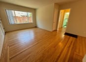 Thumbnail 2 of 19 - an empty living room with wood floors and a large window