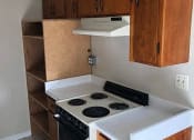 Thumbnail 7 of 36 - a small kitchen with a white stove and wooden cabinets