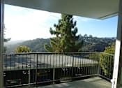 Thumbnail 5 of 10 - A balcony with a view of a tree and a mountain.