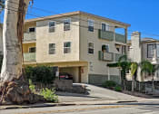 Thumbnail 7 of 36 - an apartment building with a car parked in front of it