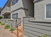 Thumbnail 34 of 37 - A concrete staircase with a metal railing leads up to a balcony.