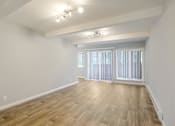 Thumbnail 11 of 27 - A room with wooden flooring and a window with blinds.