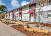 Thumbnail 3 of 53 - An angled view of the building with red awnings and landscaping