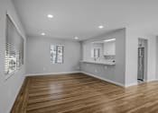 Thumbnail 21 of 31 - A spacious room with wooden flooring and white walls.