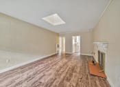 Thumbnail 14 of 21 - A room with wooden floors and a fireplace.
