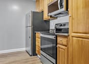 Thumbnail 31 of 32 - A kitchen with a black refrigerator, stove, and oven.