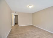 Thumbnail 8 of 13 - an empty living room with wood flooring and white walls