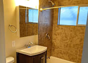 Thumbnail 32 of 36 - A bathroom with a toilet, sink, and bathtub.