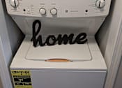 Thumbnail 27 of 63 - A white dryer with a black home sign on the front.