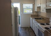 Thumbnail 17 of 42 - A kitchen with a refrigerator, sink, and stove.