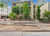 Thumbnail 14 of 17 - A building with a green tree in front of it.