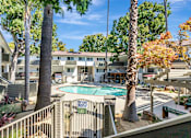 Thumbnail 6 of 43 - A pool surrounded by trees and a fence with a sign that says "No Dogs Allowed".