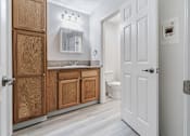 Thumbnail 25 of 29 - A bathroom with a white door and a white toilet.