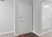 Thumbnail 28 of 33 - A white door is in a room with a carpet.