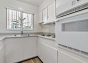 Thumbnail 48 of 52 - A white kitchen with a window and a sink.