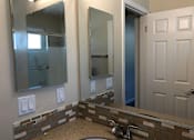 Thumbnail 31 of 62 - a bathroom with a sink and two mirrors