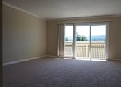 Thumbnail 19 of 30 - A room with a carpeted floor and a sliding glass door.