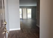 Thumbnail 27 of 30 - A hallway with wood floors and white walls.