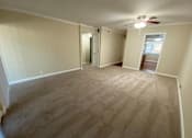 Thumbnail 17 of 23 - A room with a carpeted floor and a ceiling fan.