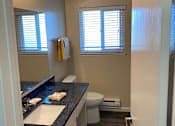 Thumbnail 39 of 43 - A bathroom with a toilet, sink, and window.