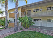 Thumbnail 6 of 38 - A building with a balcony and a palm tree in front.